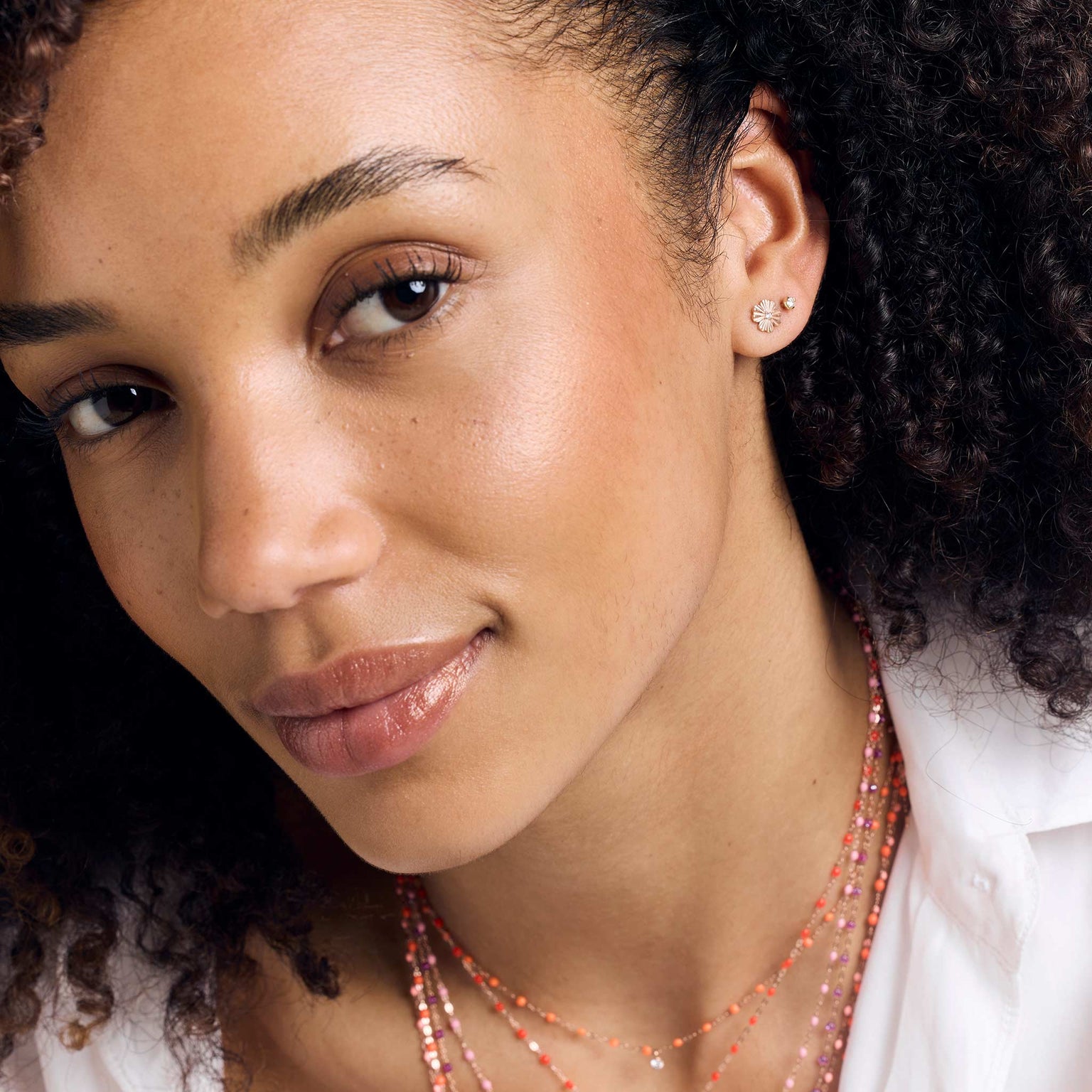 Photo du visage d'une femme portant des boucles d'oreilles Gigi Clozeau. 