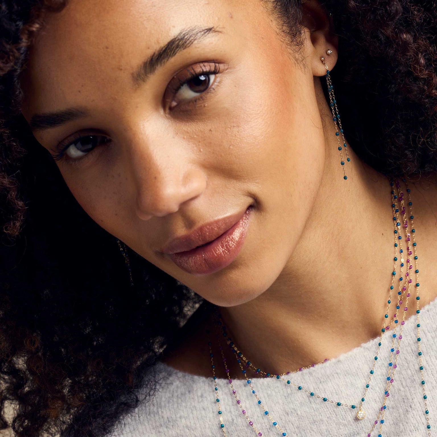 Visage d'une femme portant des boucles d'oreilles Gigi Clozeau. 