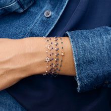 Photo du poignet d’une femme portant des bracelets Gigi Clozeau de couleur bleue.