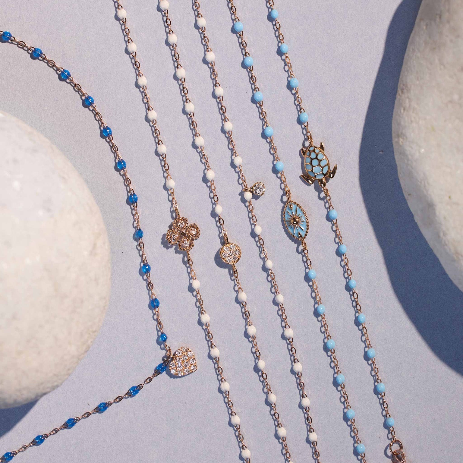 Photo de nature morte de plusieurs bracelets et d’un collier Gigi Clozeau posés.