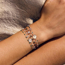 Photo d’un poignet portant plusieurs bracelets de différentes couleurs et modèles Gigi Clozeau. 