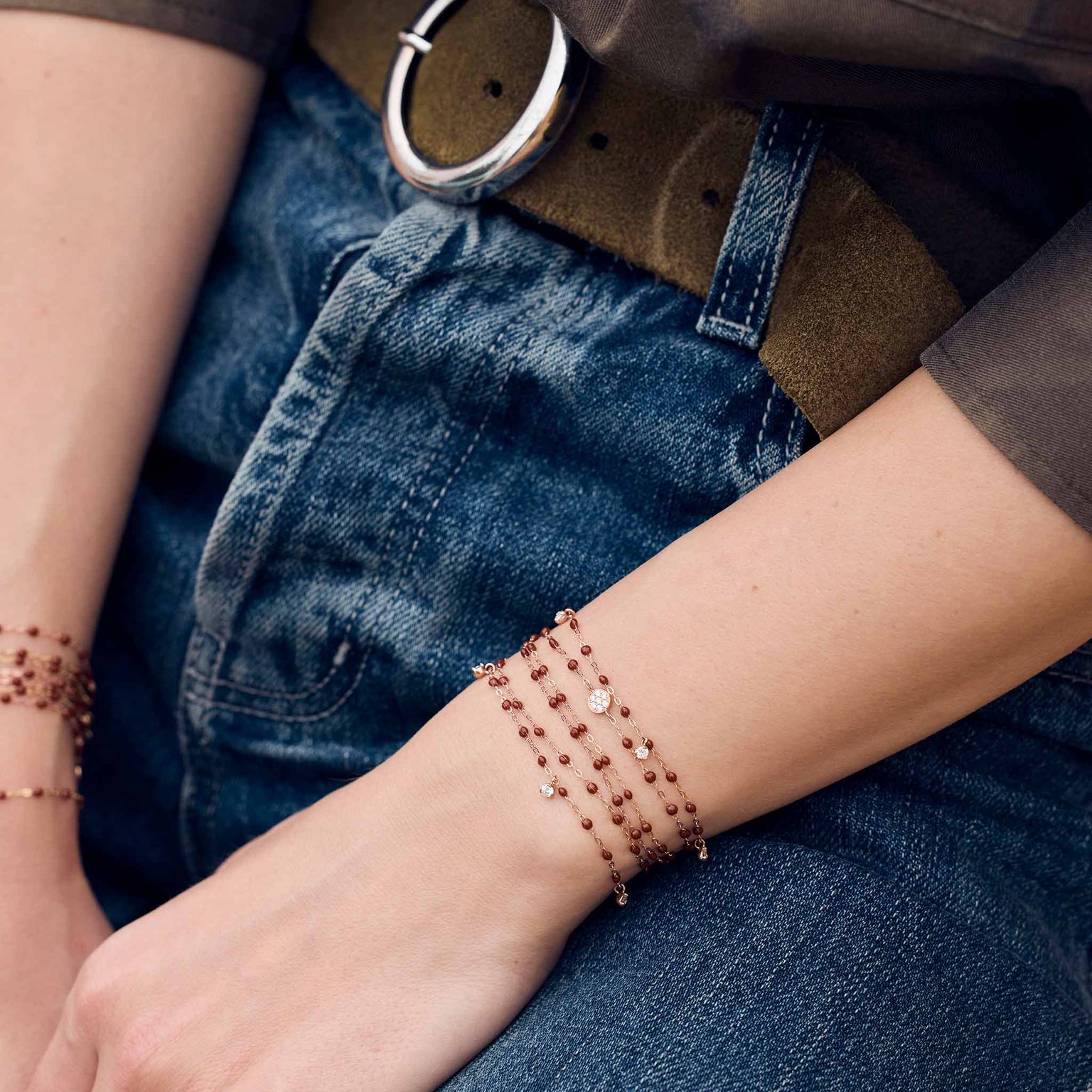 Photo des mains d’une femme portant à ses poignets des bracelets Gigi Clozeau de couleur moka.
