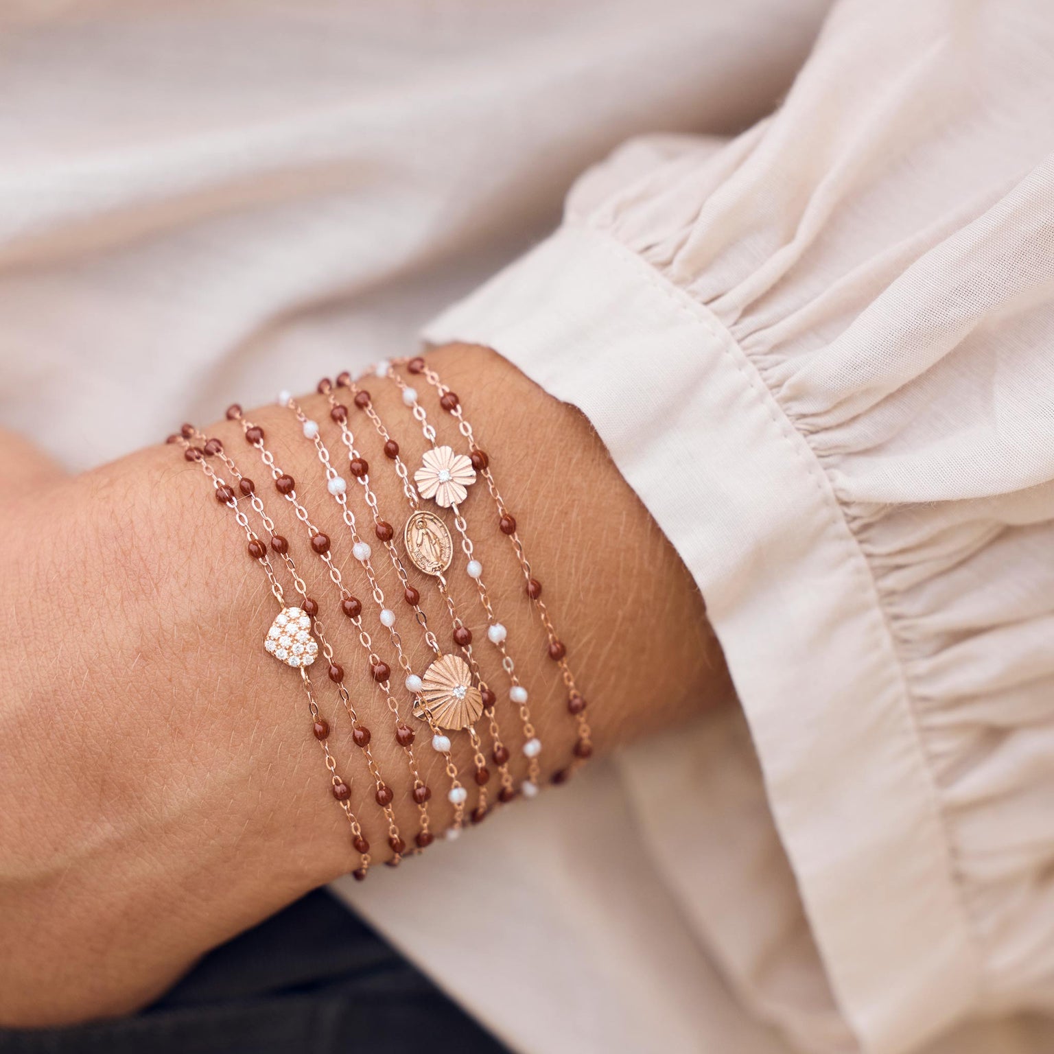 Photo du poignet d’une femme portant des bracelets Gigi Clozeau de couleur moka et opale.