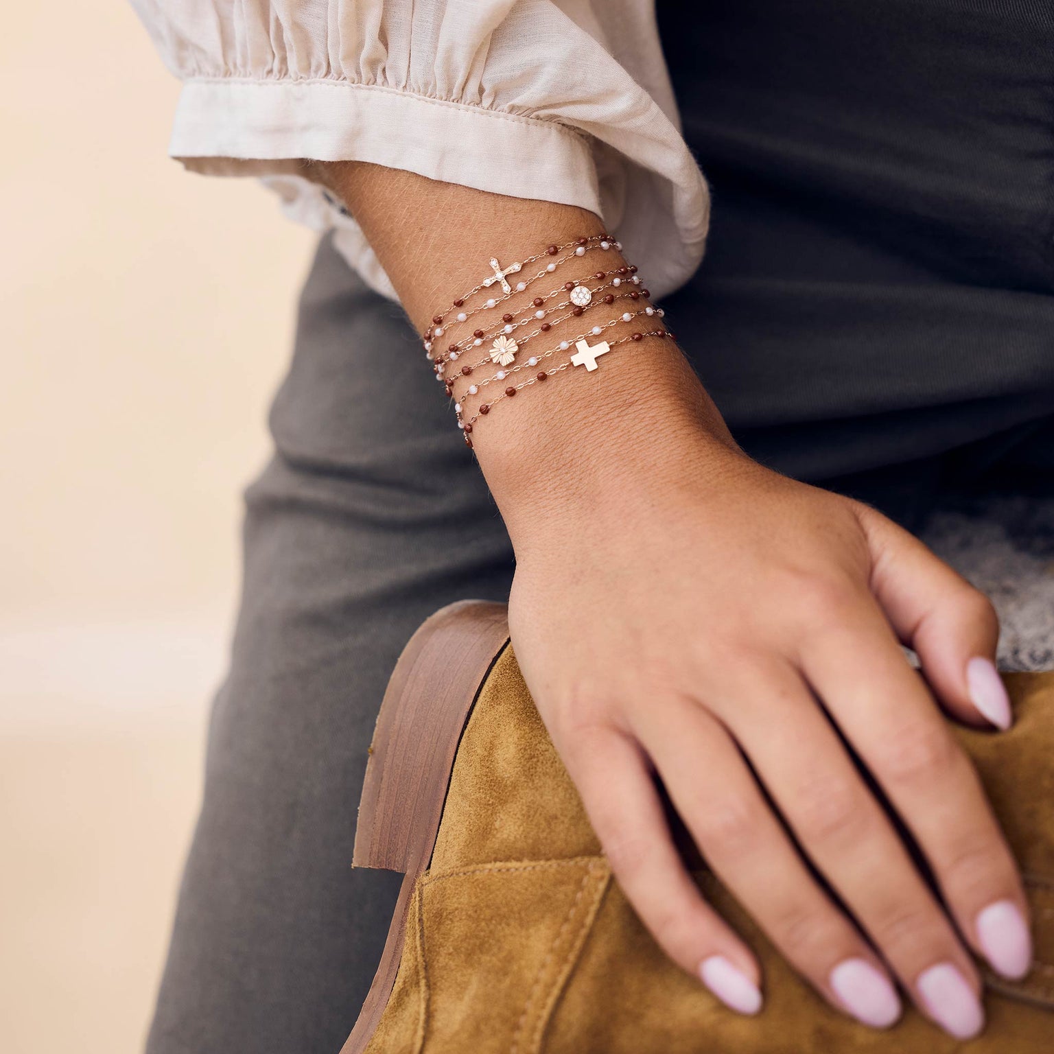 Photo du poignet d’une femme portant des bracelets Gigi Clozeau de couleur moka et opale.