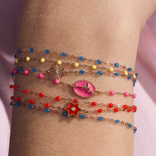 Photo du poignet d’une femme portant des bracelets colorés Gigi Clozeau.