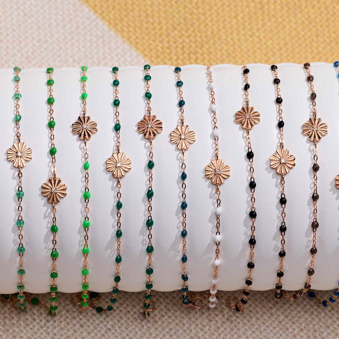 Photo de bracelet Trèfle Lumière Gigi Clozeau de différentes couleurs sur un oli 