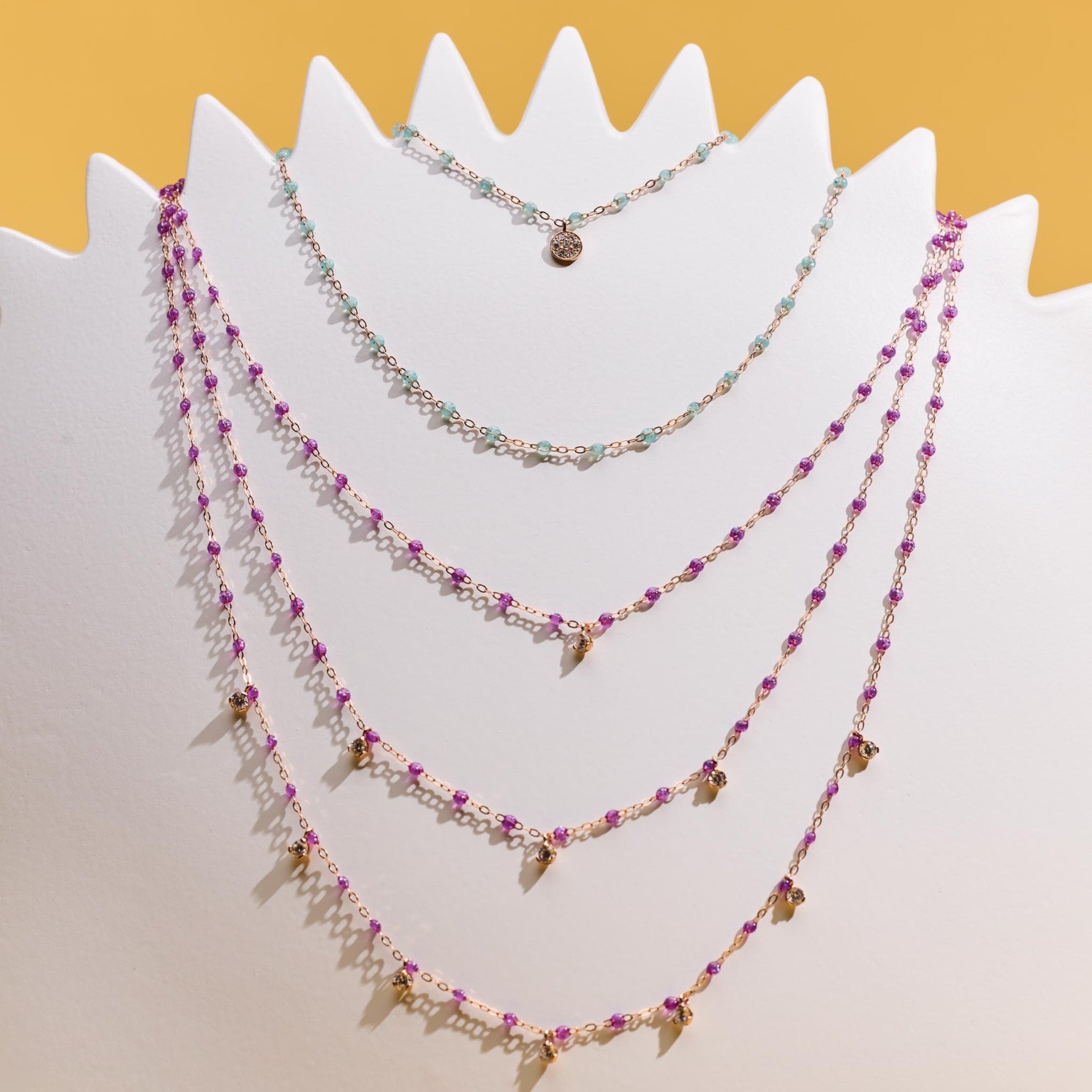 Photo de plusieurs colliers Gigi Clozeau suspendus. 