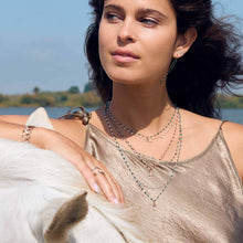 Photo du cou d’une femme portant plusieurs colliers de différentes couleurs et modèles de Gigi Clozeau.