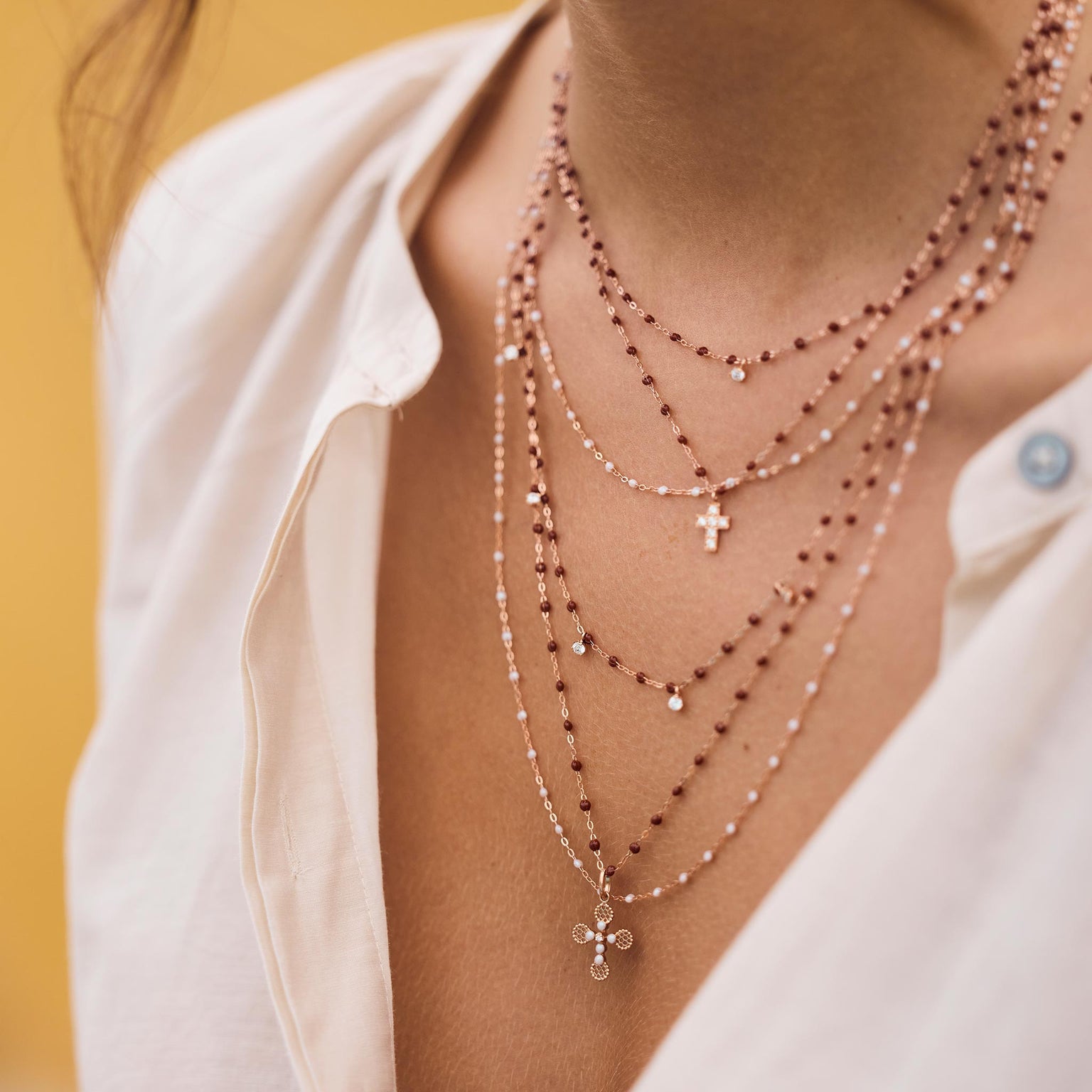 Photo du cou d’une femme portant des colliers Gigi Clozeau de couleurs opale et moka.