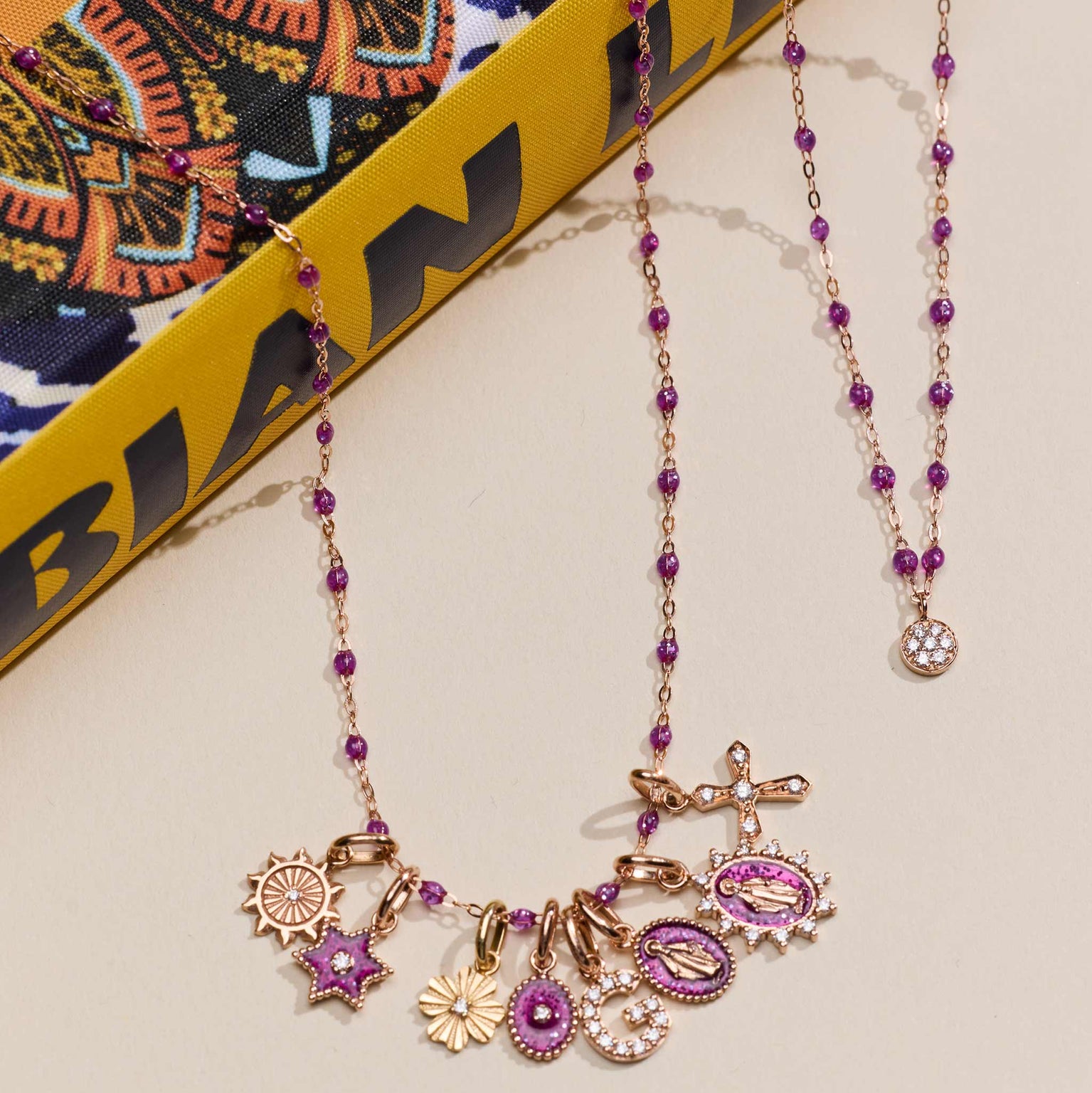 Photo de différents pendentifs sur un collier posé sur un livre.